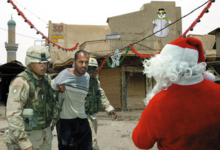 U.S. soldiers instruct an Iraqi to tell Santa what he wants for Christmas.